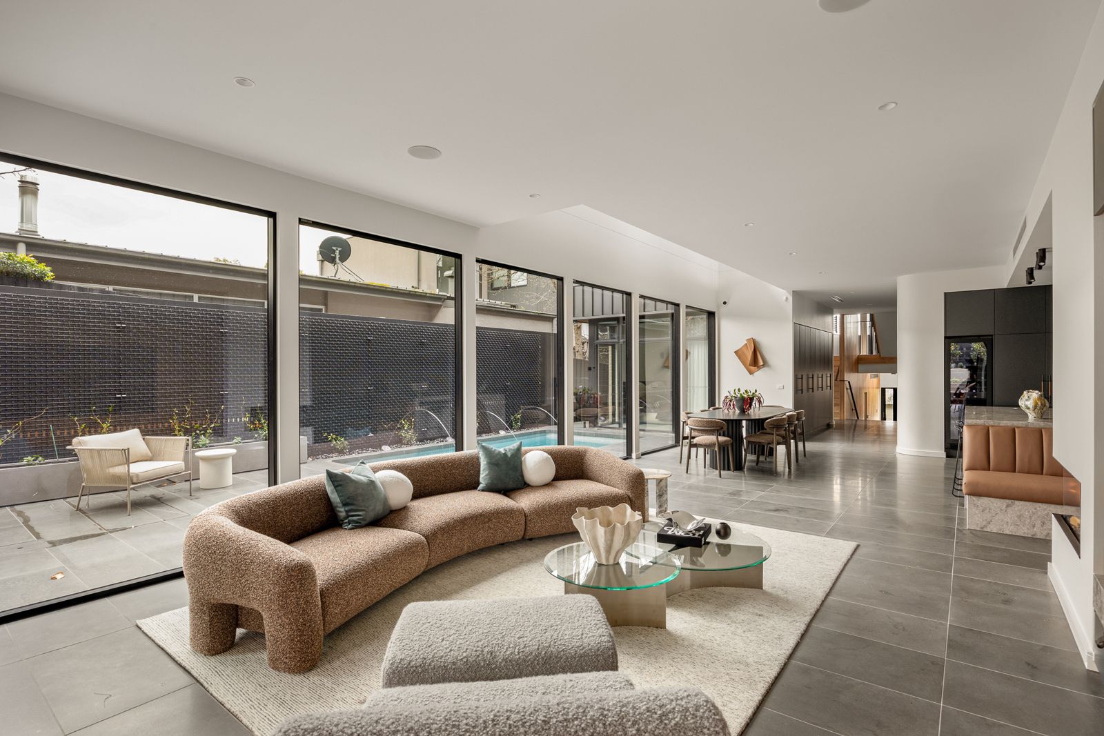 Living room at The Ora with glazing opening to the pool terrace