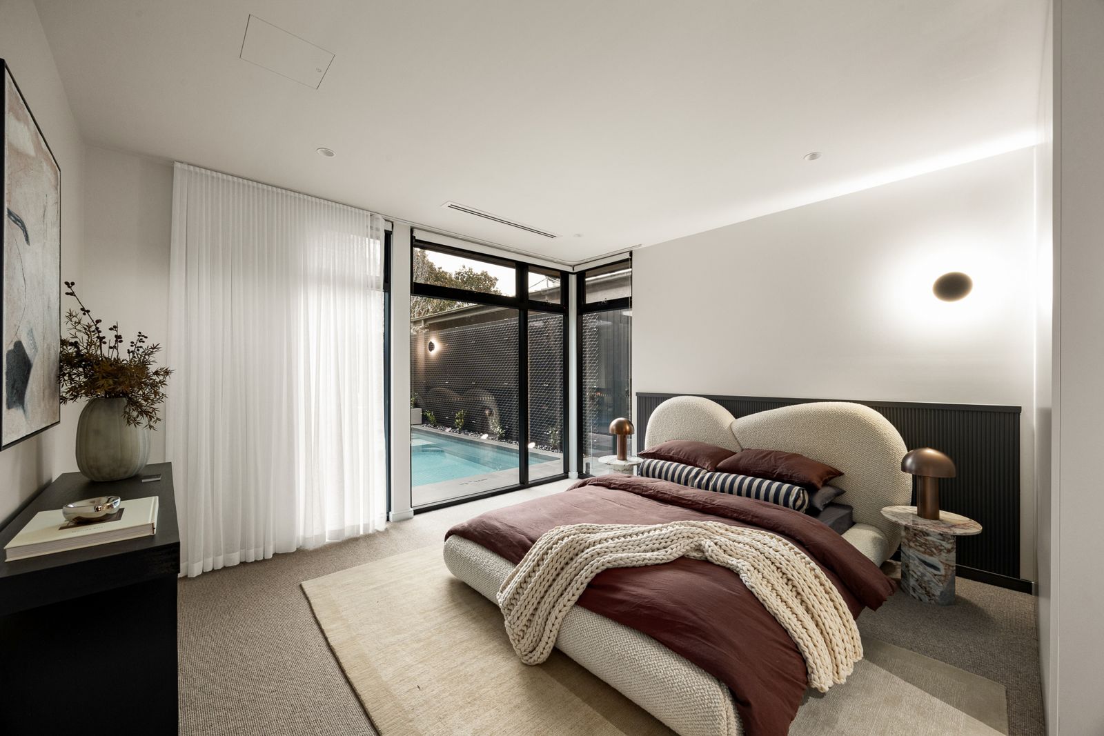 Master bedroom at The Ora with glazing overlooking the pool