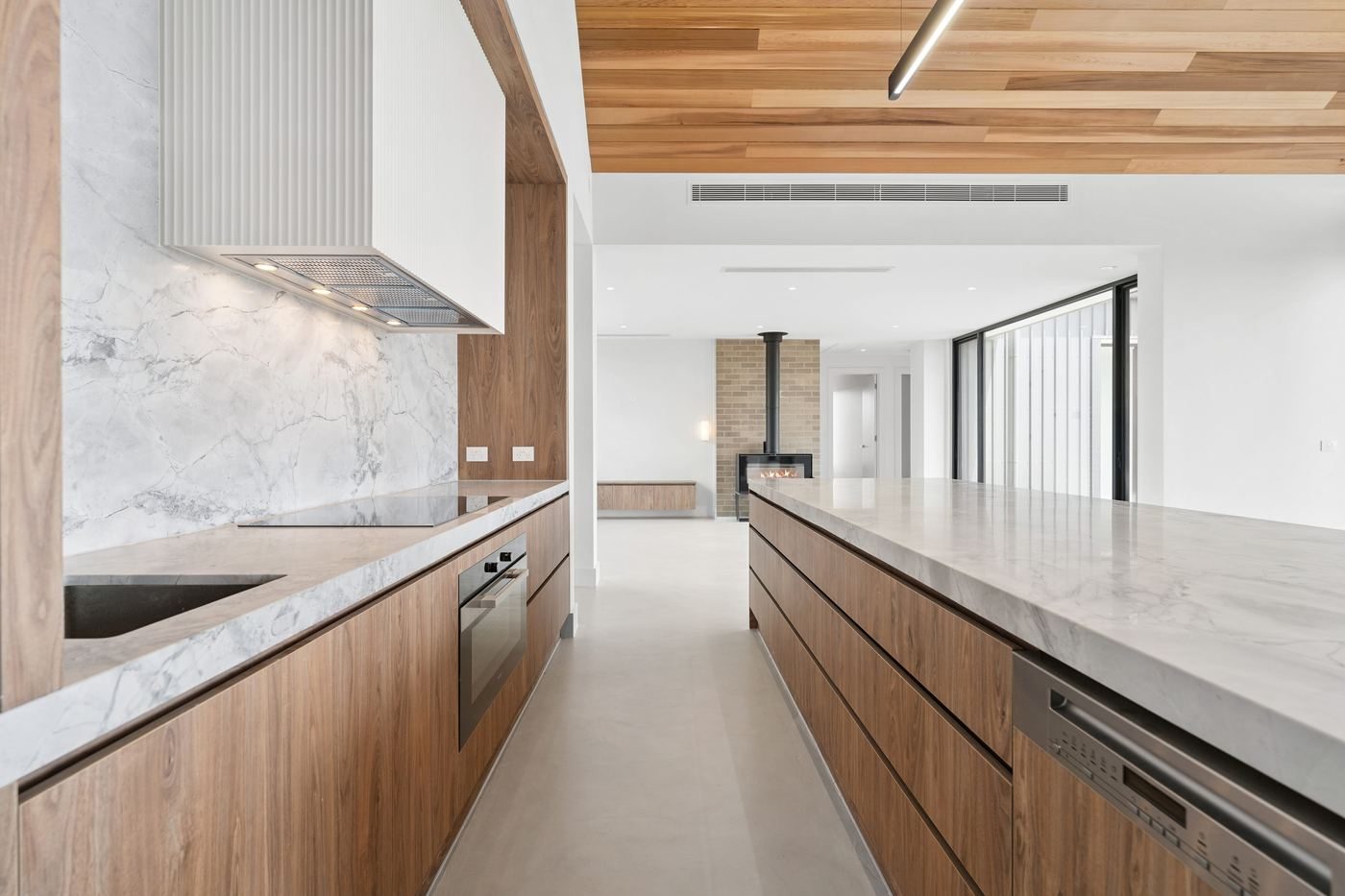 Kitchen at Musk with a long timber-fronted island and stone benchtop