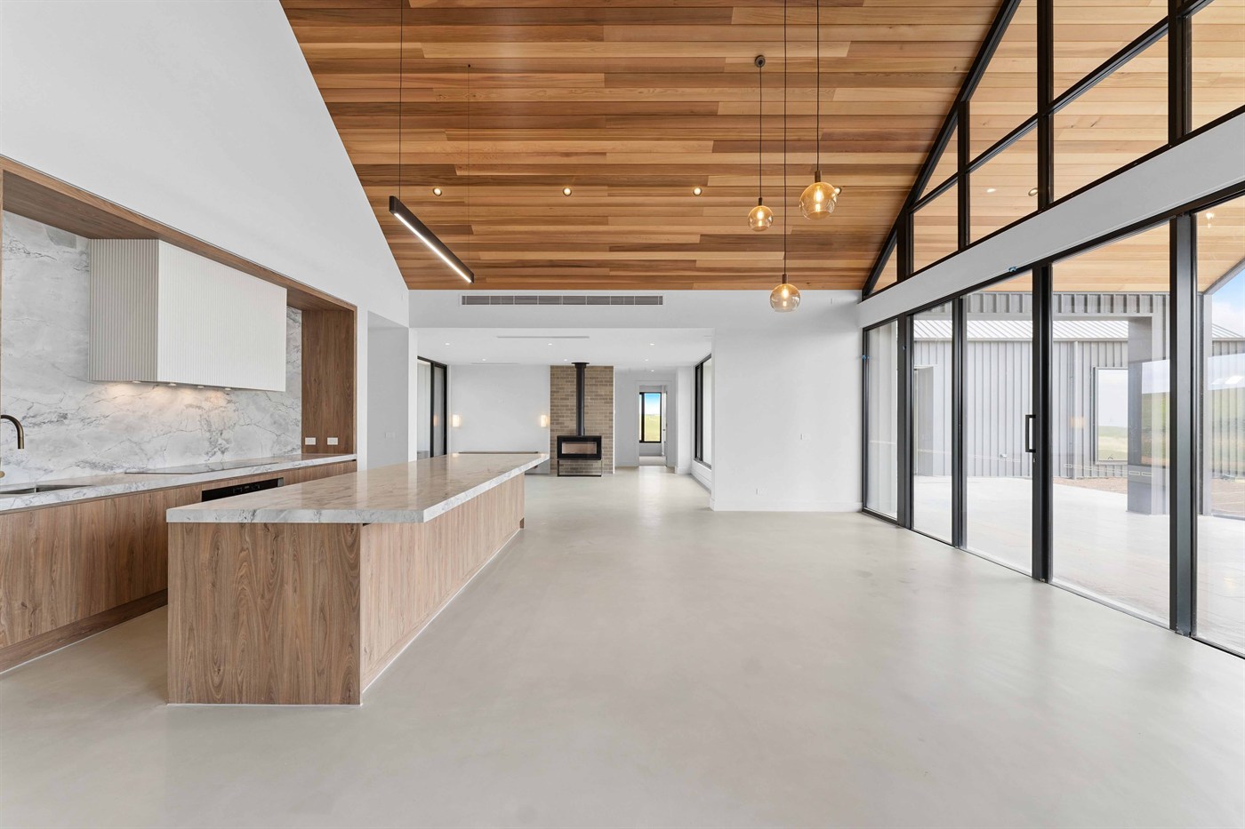 Open-plan kitchen and living area at Musk with a long island bench opening to the paddocks