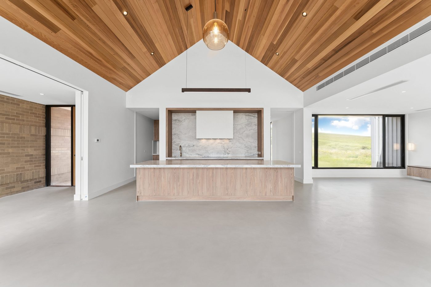 Open kitchen and living space with a vaulted timber ceiling in a Varcon custom home
